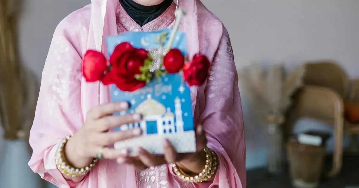 An asian woman holding a flowery gift.
